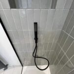 a shower head with a hose attached to the wall